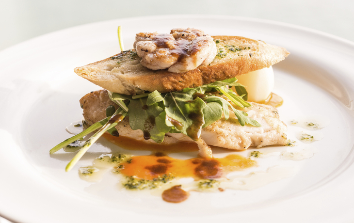 schmackhaft zubereitetes Hähnchenbrustfilet zwischen zwei Scheiben frischen Kreuterbaguette