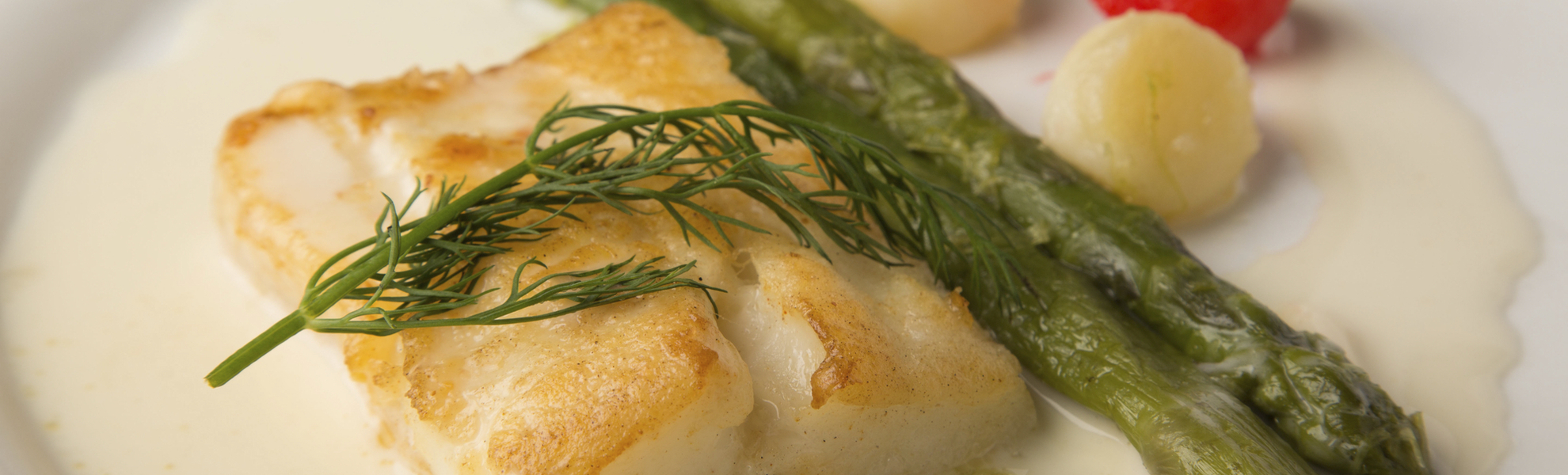 Gebratene Alaska Heilbuttschnitte Trueffel Beurre Blanc gruener Spargel Kartoffelperlen