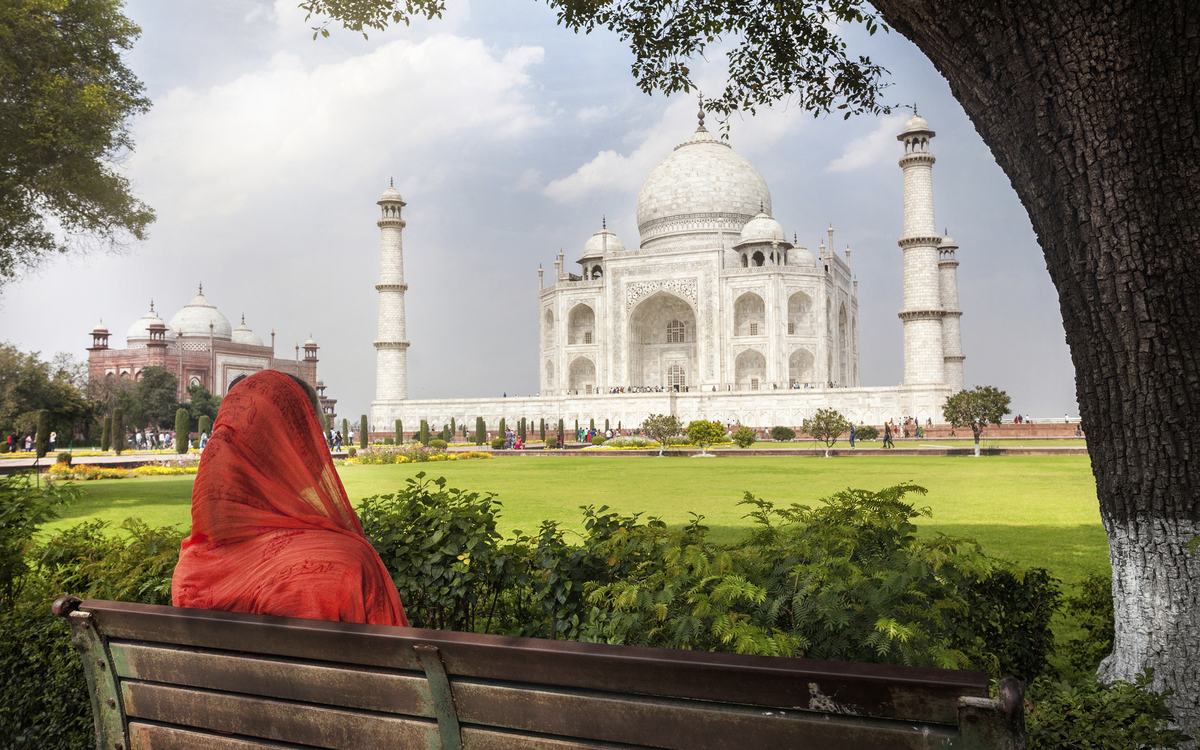 Einheimische sitzt auf der Bank vor dem Taj Mahal in Agra, Indien