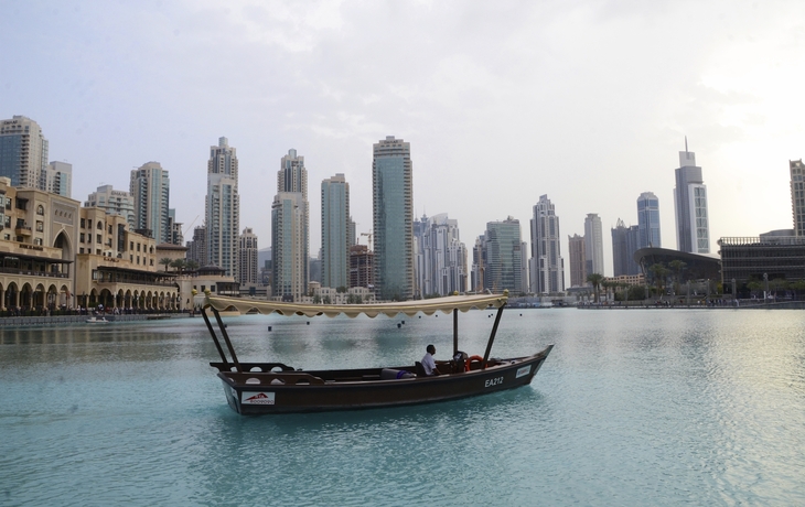 Boot im Vordergrund der Skyline Dubais, VAE