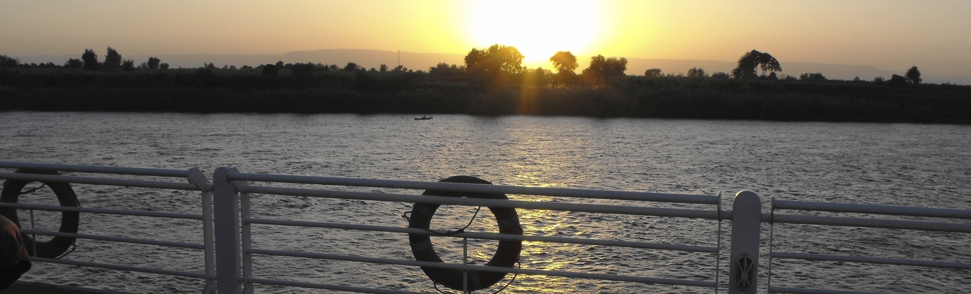 Blick von einem Schiff auf den Sonnenuntergang über dem Nil in Ägypten