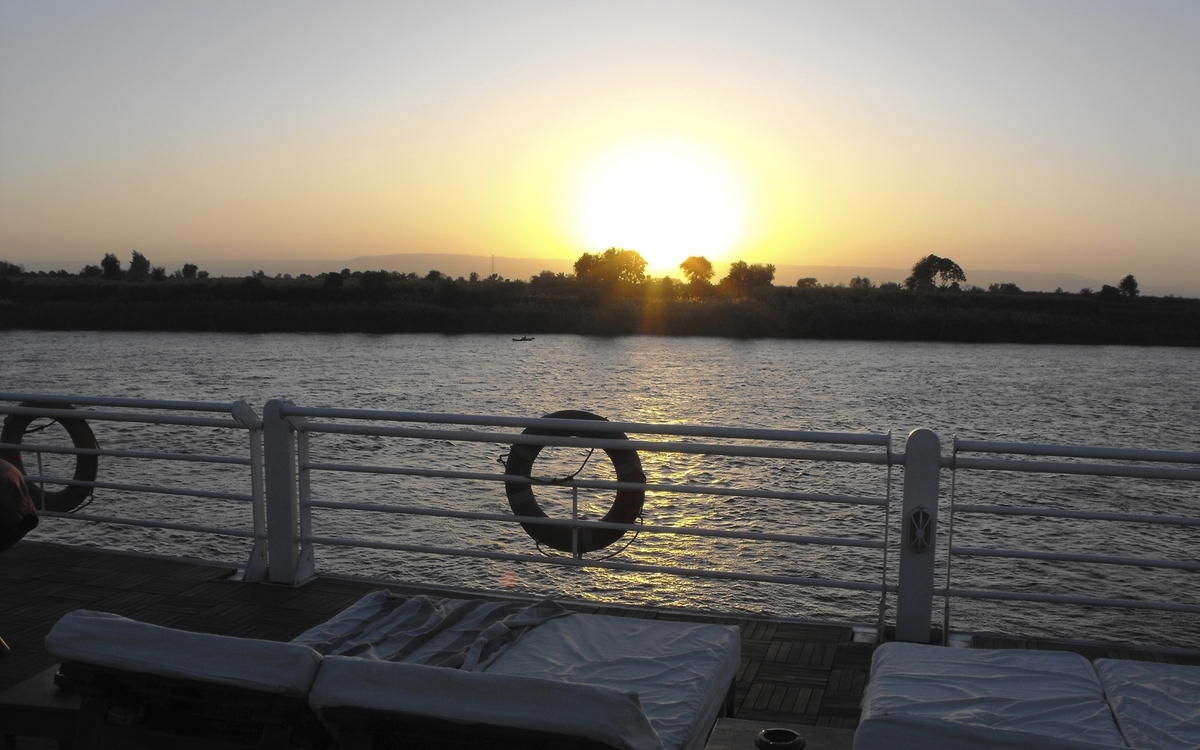 Blick von einem Schiff auf den Sonnenuntergang über dem Nil in Ägypten