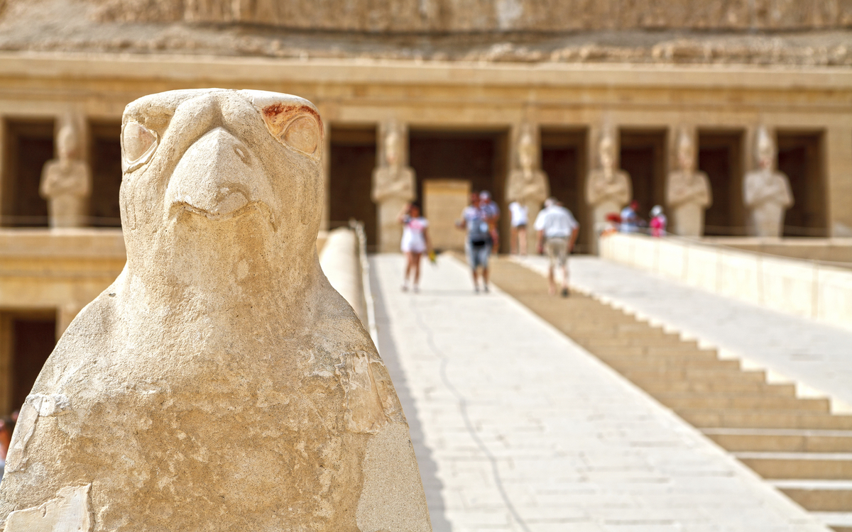 Totentempel der Hatschepsut in Ägypten mit einer Statue eines Vogels im Vordergrund