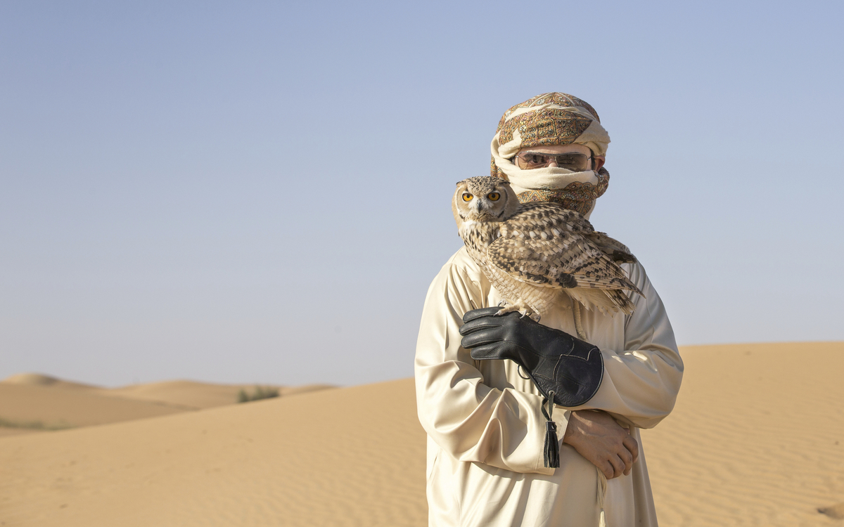 Araber mit seiner Eule in der Wüste, V. A. Emirate