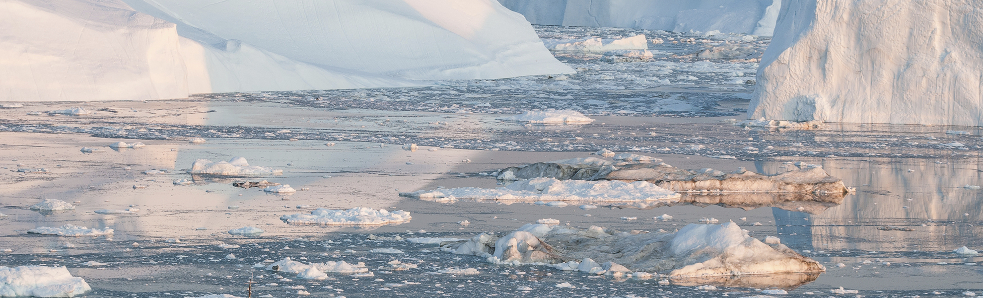 Kleines Fischerboot vor den Eisbergen in Groenland