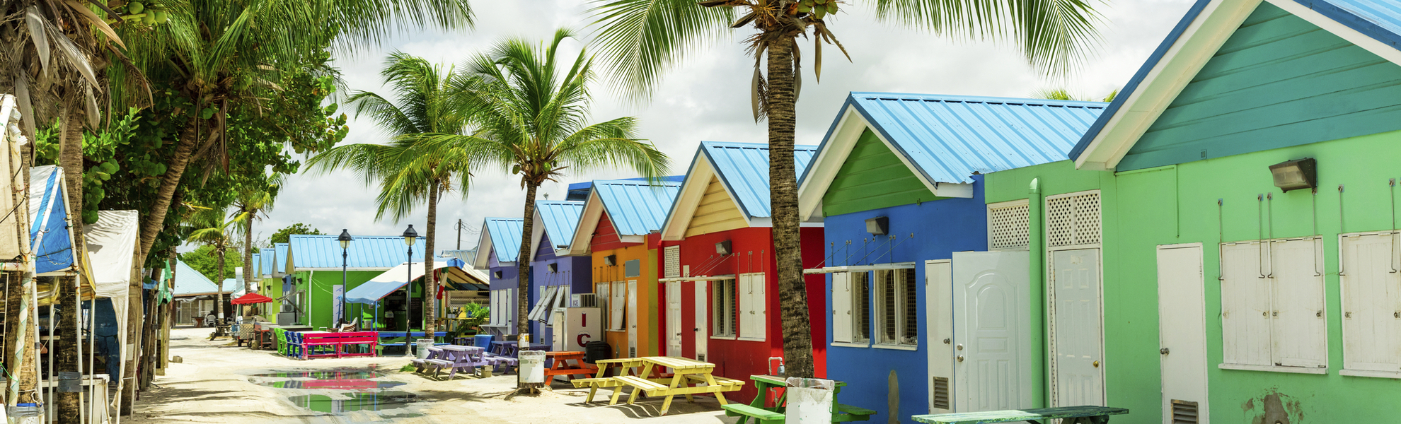 Bunte Liegestühle vor den bunten Strandhäusern auf Barbados, Karibik