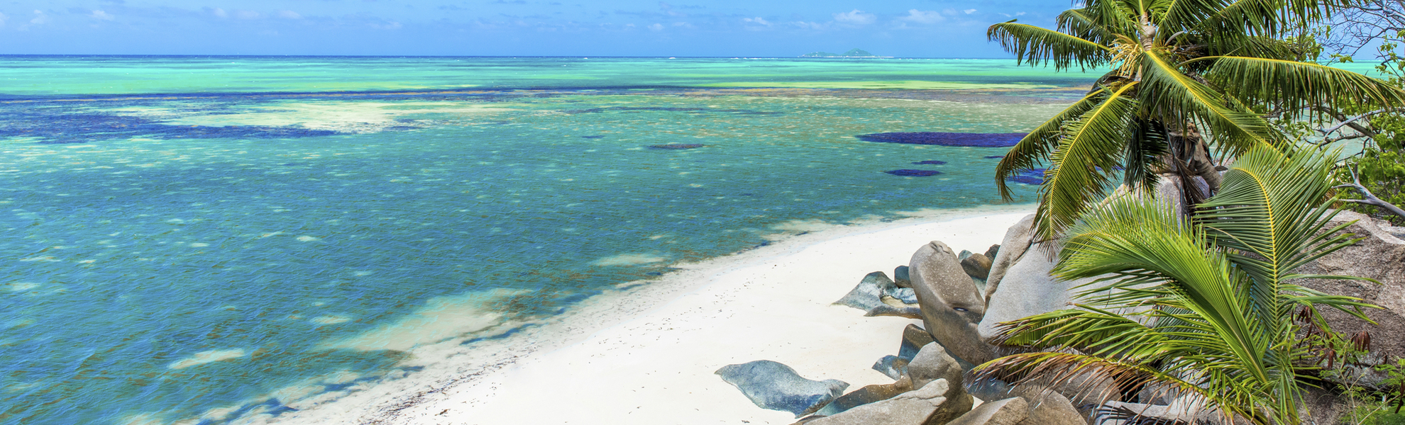 Strand mit Felsen und Palmen in Praslin, Seychellen