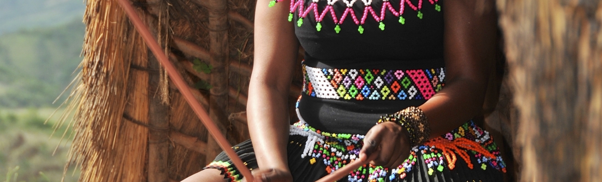 Südafrikanische, traditionell gekleidete Frau beim trommeln