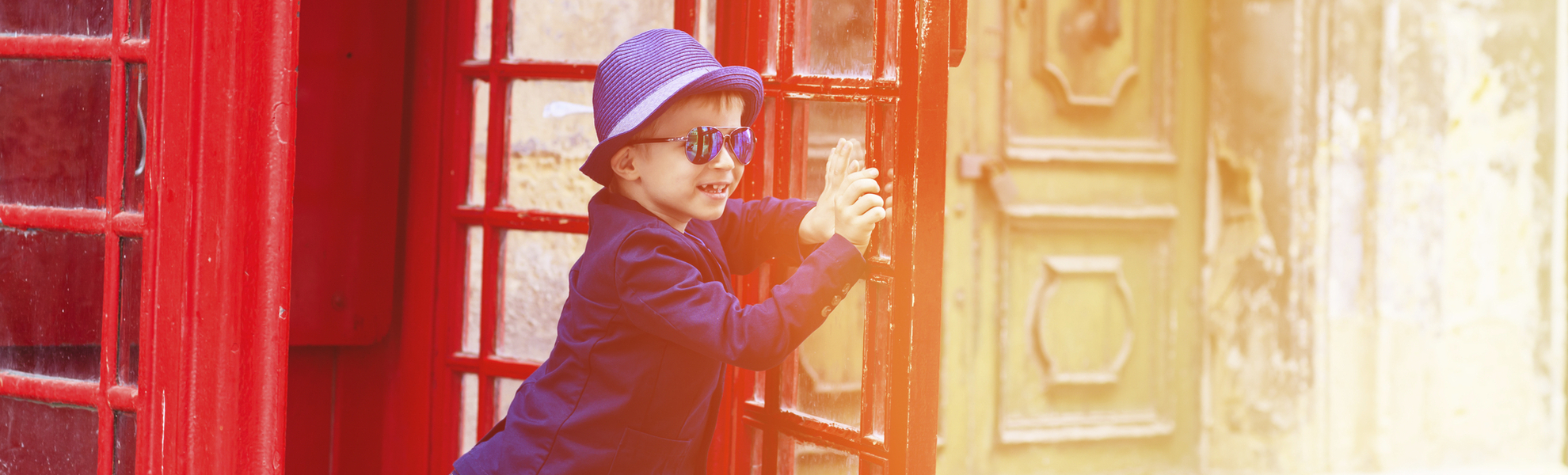 Junge in traditioneller Telefonzelle, England