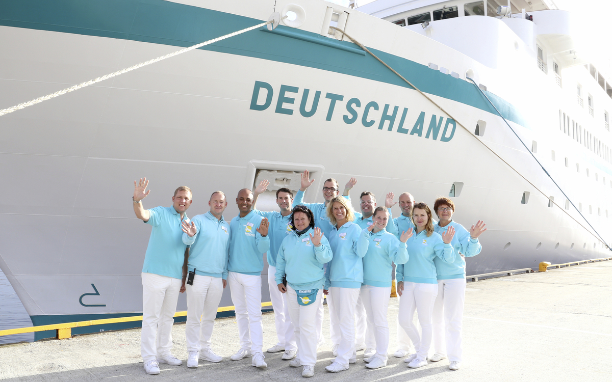Reiseleiter vor dem Bug der MS Deutschland