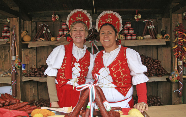 Traditionell gekleidete Frauen an einem Stand in der Markthalle in Budapest, Ungarn