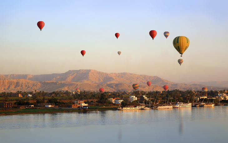 Heißluftballons über dem Nil, Luxor und dem Tal der Könige beim Sonnenuntergang in Ägypten