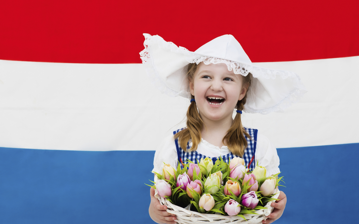 Mädchen in Tracht vor Landesfahne