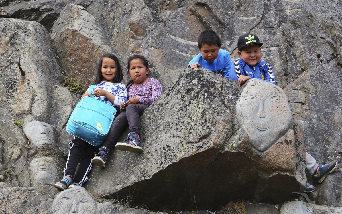 Kinder an steinernem Ornament in Qaqortoq, Grönland