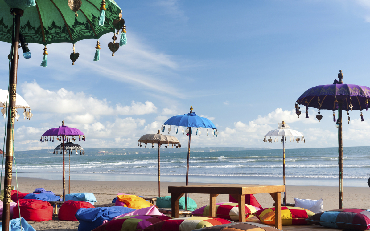 Strand mit bunten Schirmen, Indonesien