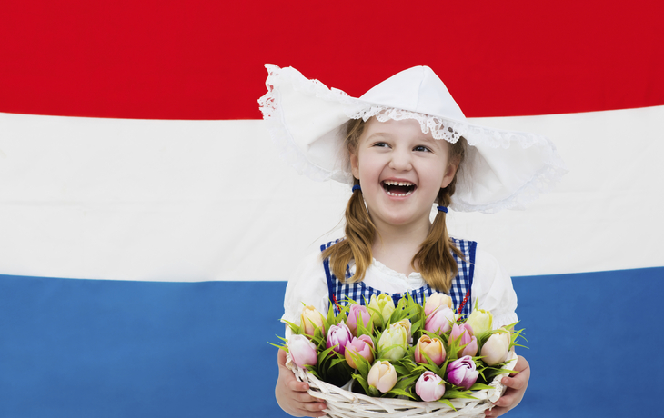 Mädchen in Tracht vor Landesfahne