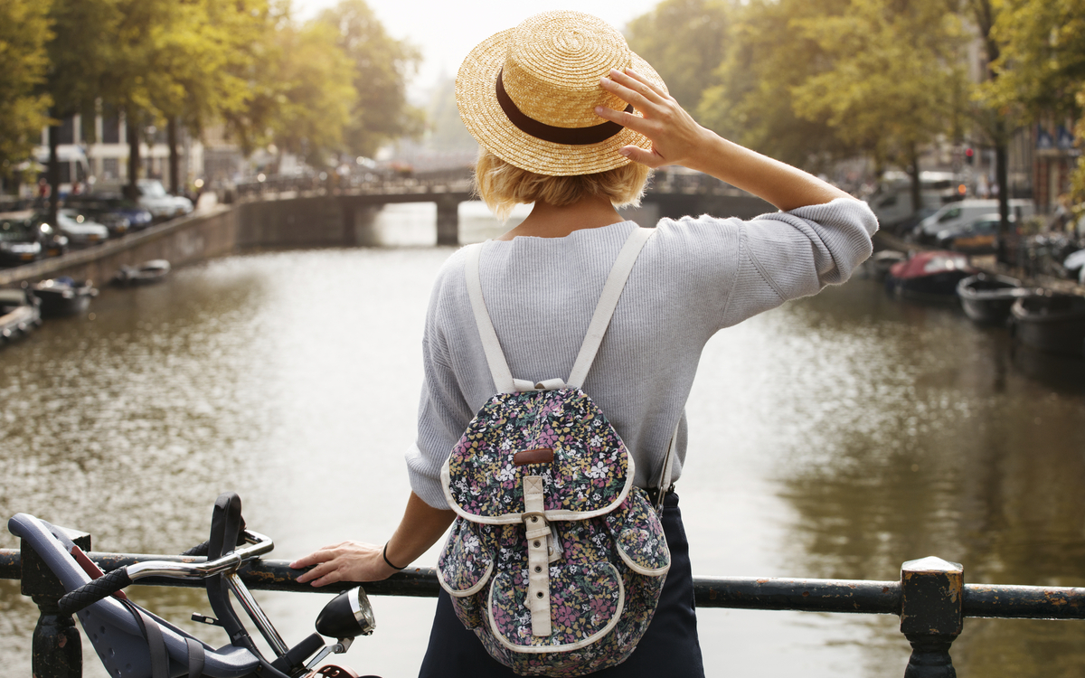 Frau am Kanal an einer Gracht in Amsterdam