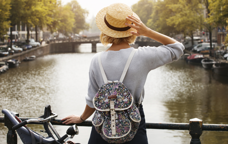 Frau am Kanal an einer Gracht in Amsterdam