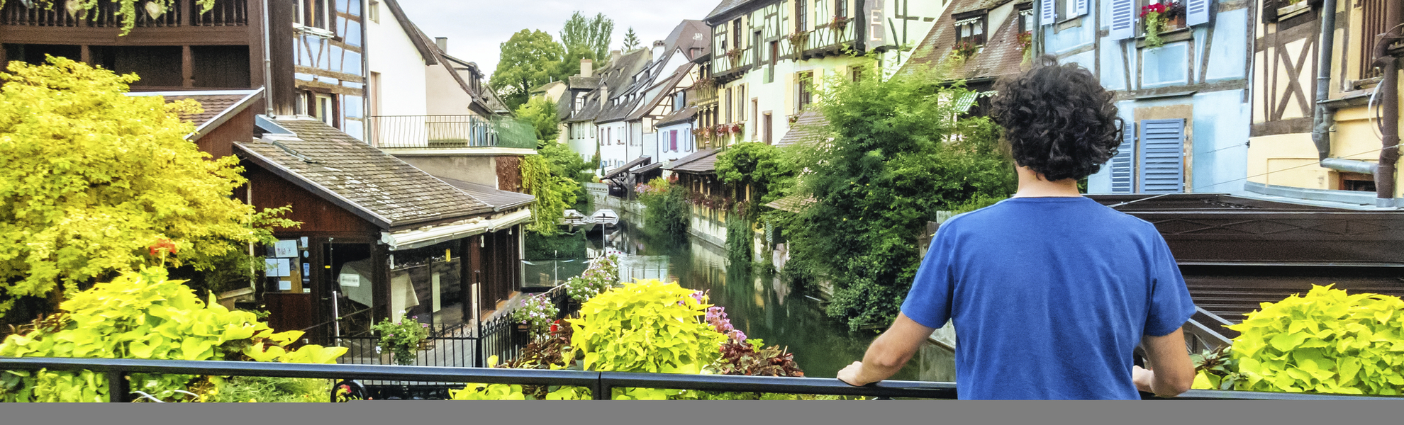 Mann am Brückengeländer eines Kanals in Colmar, Frankreich