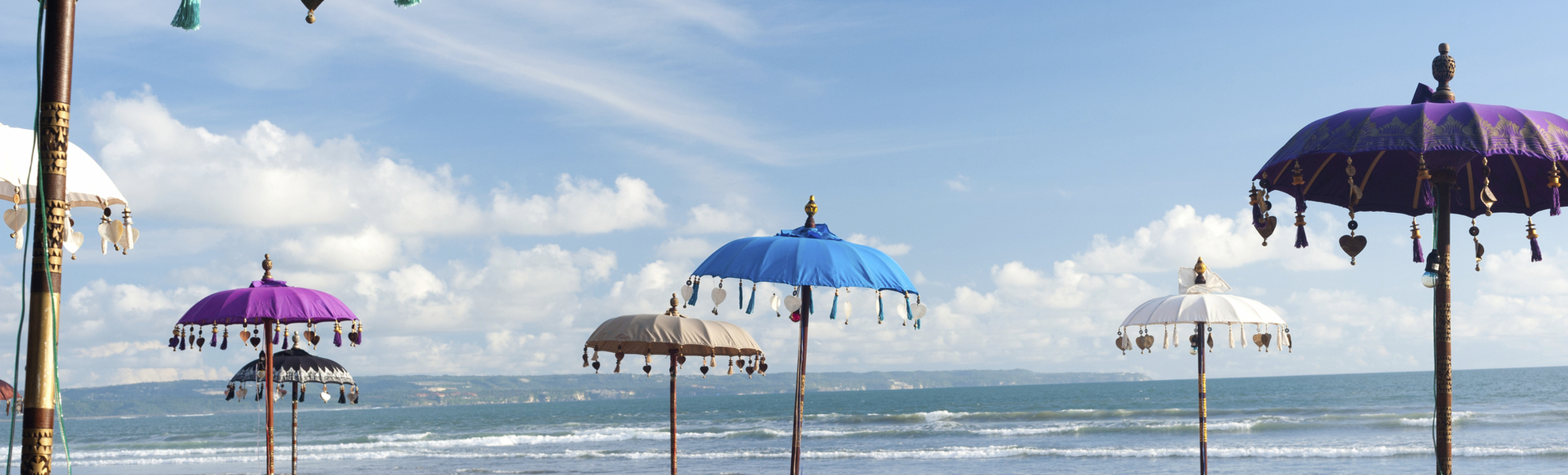 Strand mit bunten Schirmen, Indonesien