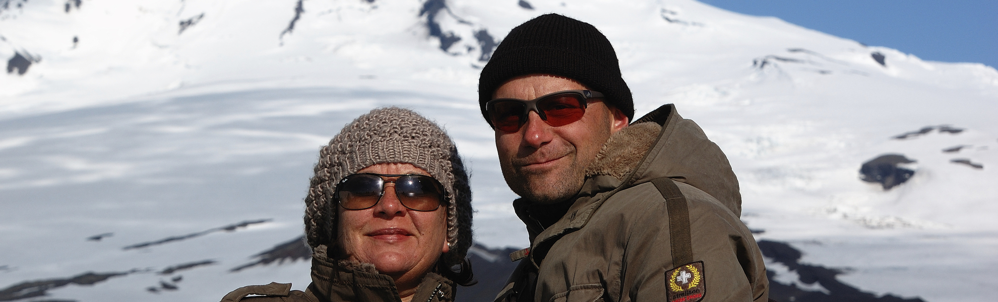 Menschen bestaunen einen Vulkan in Spitzbergen