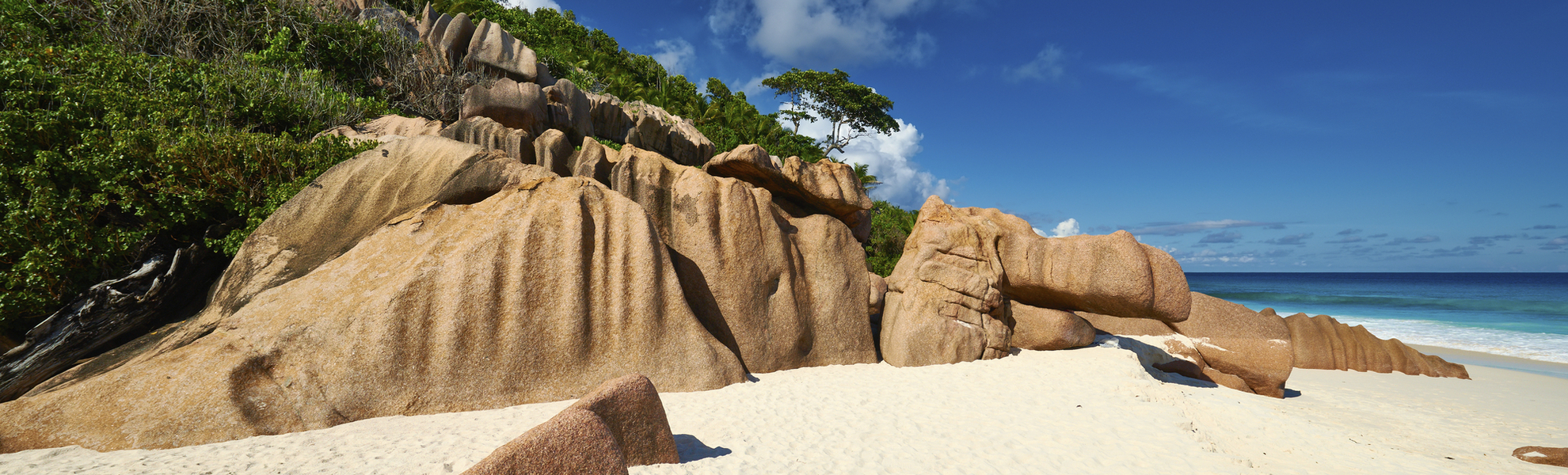 Feiner Sandstrand im Windschatten der Felsen auf La Digue, Seychellen