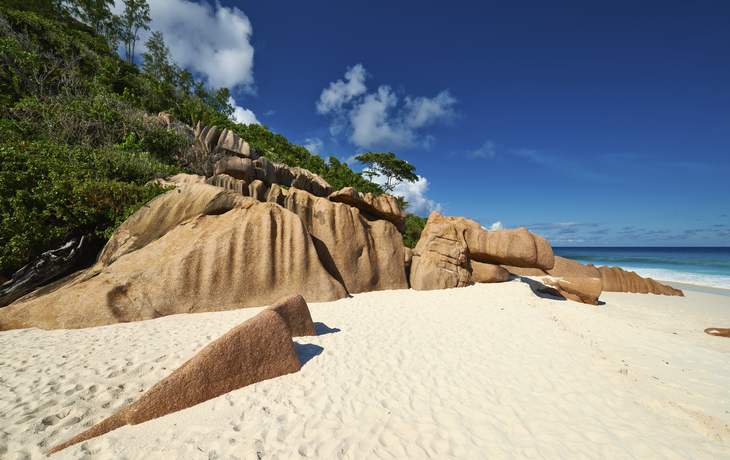 Feiner Sandstrand im Windschatten der Felsen auf La Digue, Seychellen