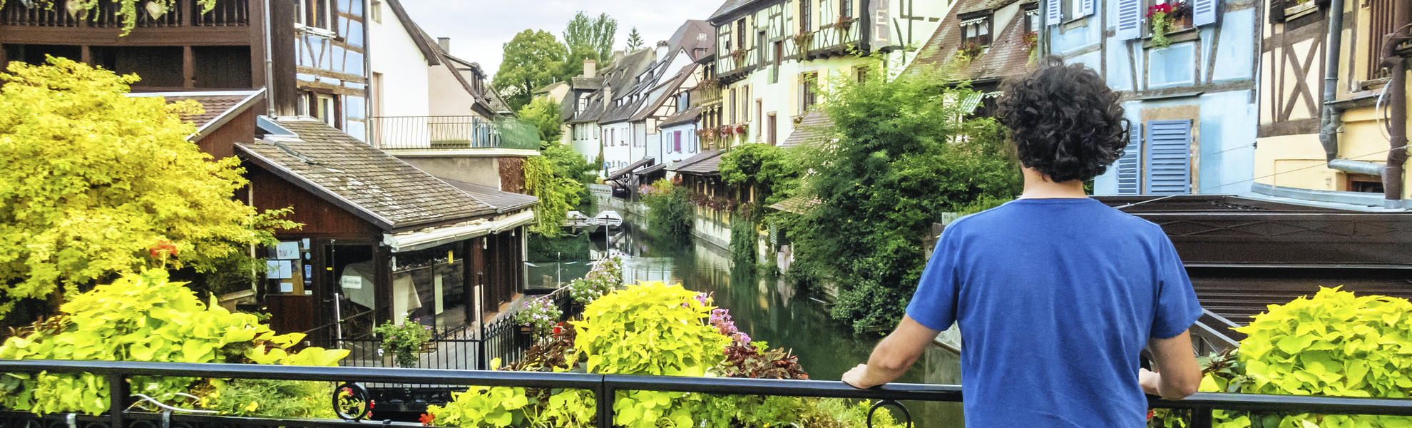 Mann am Brückengeländer eines Kanals in Colmar, Frankreich