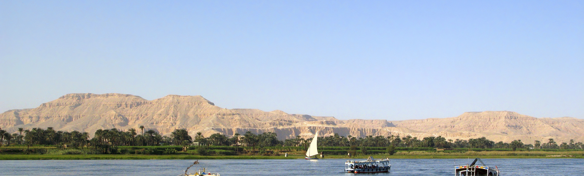 Schiffe auf dem Nil vor schöner Nillandschaft in Ägypten