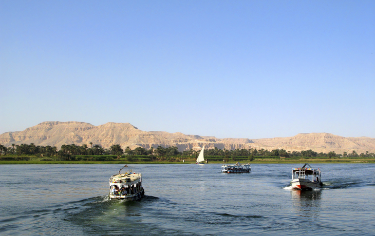 Schiffe auf dem Nil vor schöner Nillandschaft in Ägypten