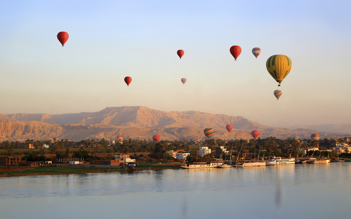 Heißluftballons über dem Nil, Luxor und dem Tal der Könige beim Sonnenuntergang in Ägypten