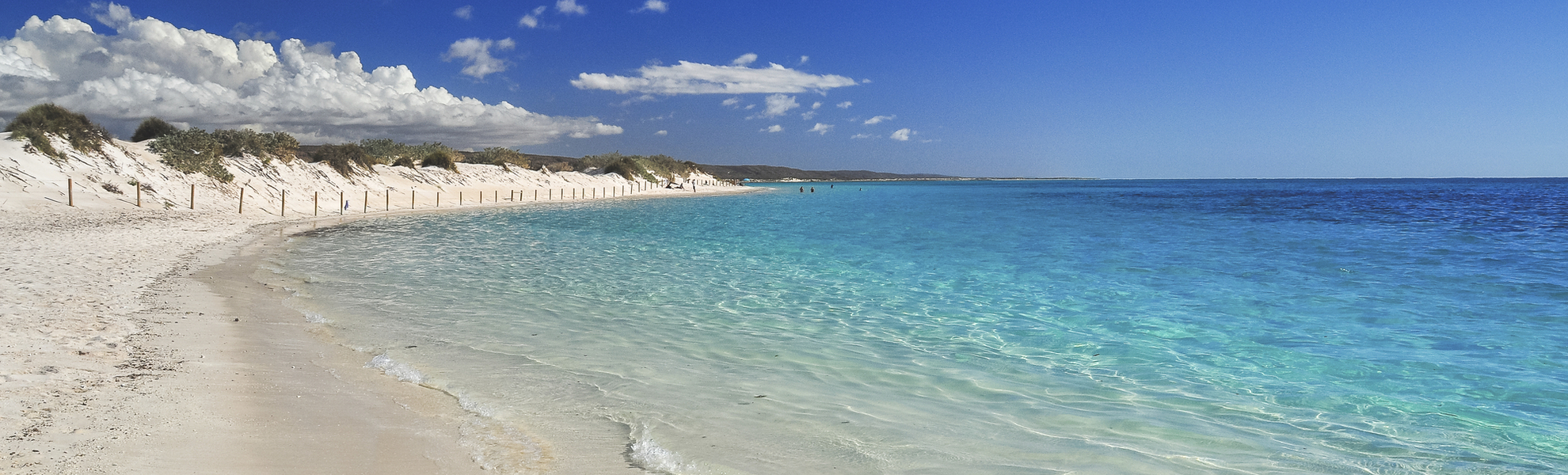 Weißer Sandstrand mit türkisblauem Wasser