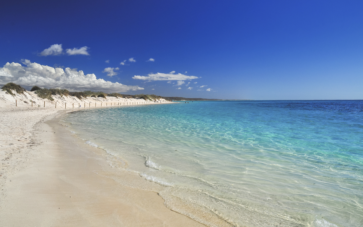 Weißer Sandstrand mit türkisblauem Wasser