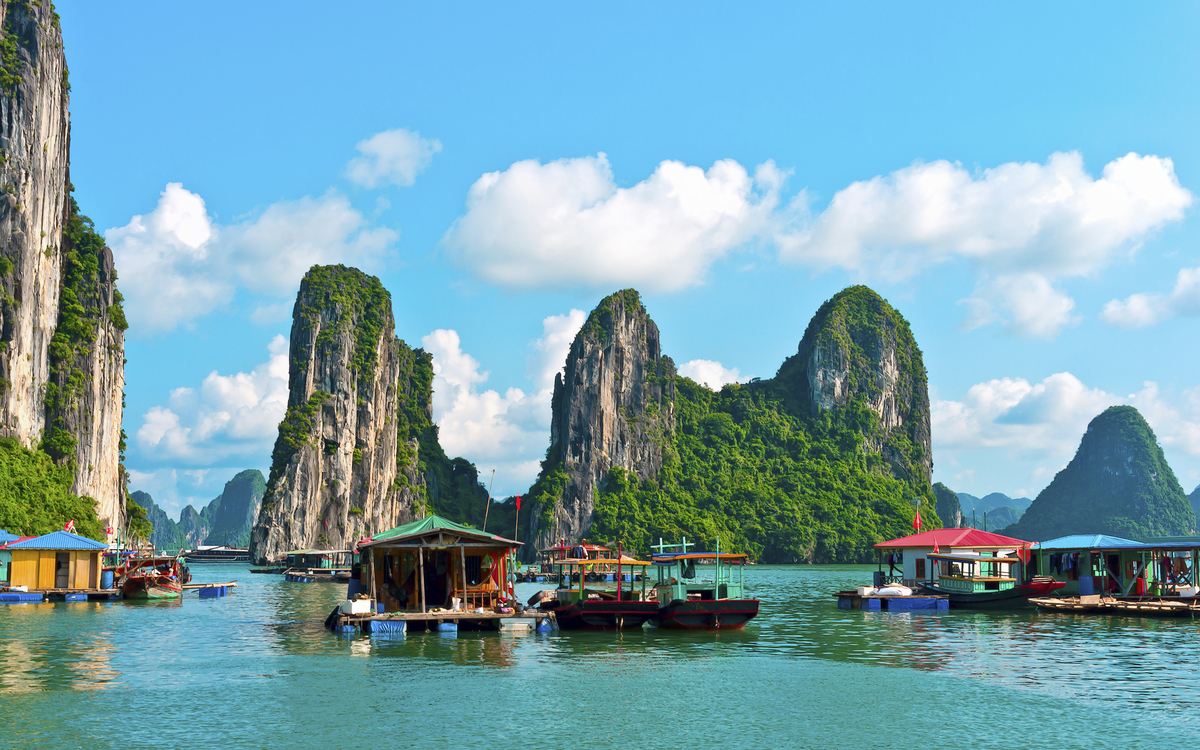 Hausboote vor Felseninseln in der Halong Bucht, Vietnam