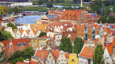 Historische Häuser mit roten Ziegeldächern säumen einen Kanal in Danzig