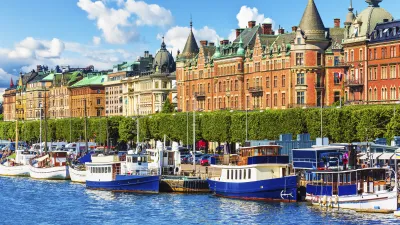 Boote liegen am Kai vor historischen Gebäuden in Stockholm.
