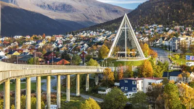 Brücke führt durch bunte Stadtlandschaft mit markanter Kirche.