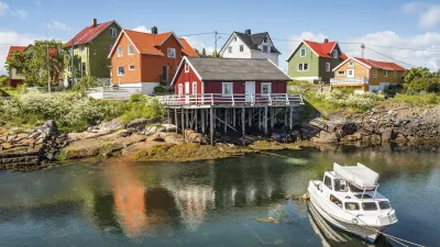 Bunte Häuser am Wasser spiegeln sich im ruhigen Hafen.
