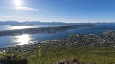 Blick über Tromsø mit Häusern, Wasser und Bergen im Hintergrund