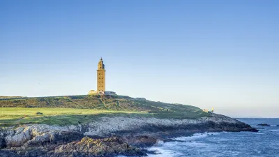 Der Herkulesturm steht auf einer felsigen Küste mit Blick auf das Meer.