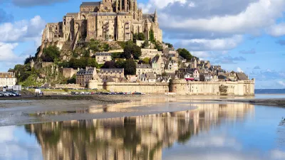 Historische Burg auf einer Gezeiteninsel spiegelt sich im Wasser.