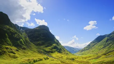 Grüne Hügel und Berge prägen die schottische Landschaft in Glencoe.