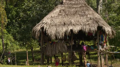 Traditionelles Emberá-Häuschen mit Menschen davor