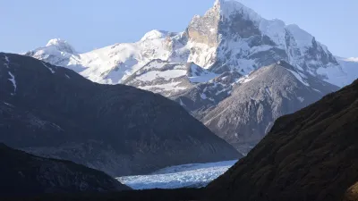 Schneebedeckte Berge spiegeln sich im ruhigen Wasser des Kanals