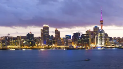 Auckland Skyline bei Nacht mit beleuchteten Gebäuden und dem Sky Tower.