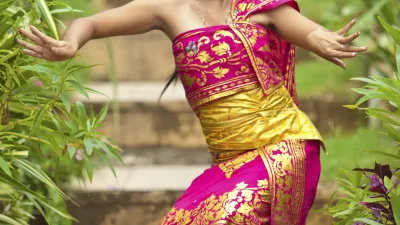 Tänzerin in traditioneller Kleidung auf Bali präsentiert ihre Kunst.