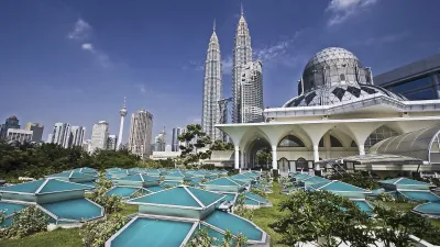 Petronas Türme ragen hinter einer Moschee mit Wasserspielen auf