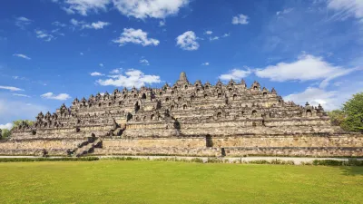 Historischer Borobudur-Tempel in Indonesien mit grüner Wiese.