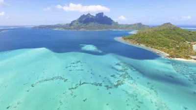 Türkisblaues Meer umgibt die grüne Insel Bora Bora im Pazifik.