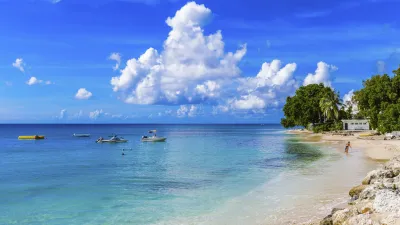 Türkisblaues Karibisches Meer trifft auf einen sonnigen Sandstrand.